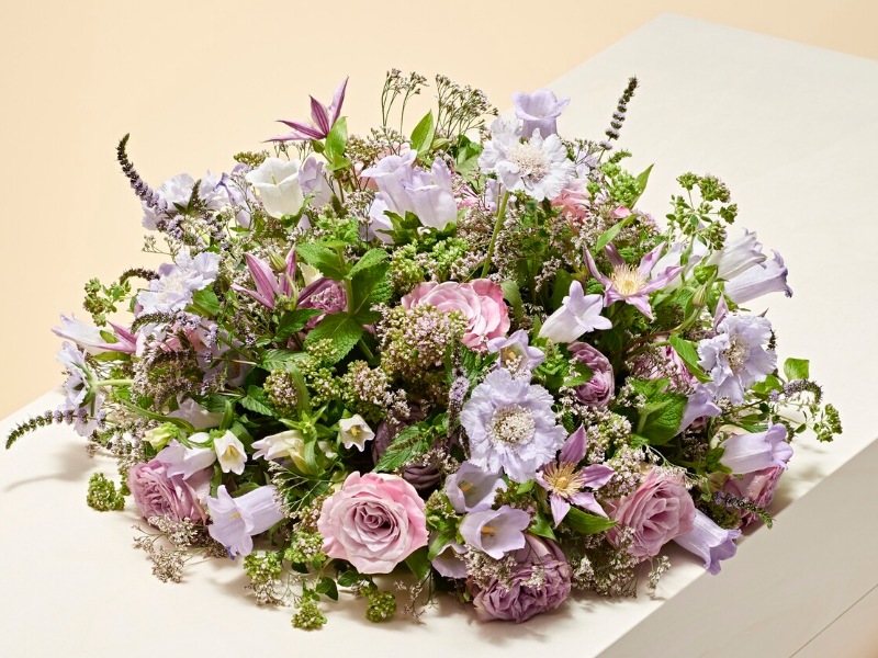 Biedermeier Paarse Rozenkring: rond rouwstuk met rozen en bloemen in paarstinten